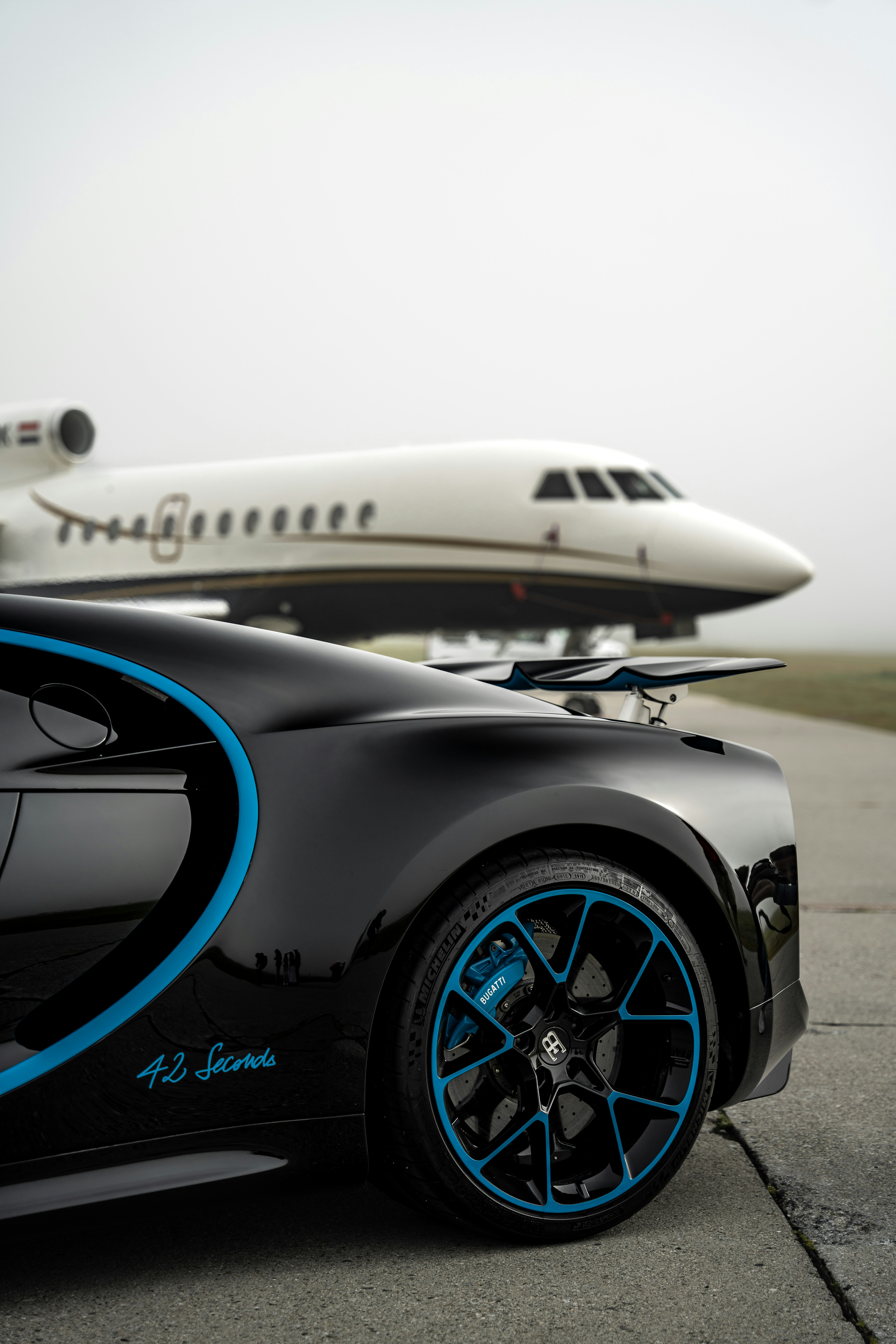 Luxury Bugatti sports car with private jet in background